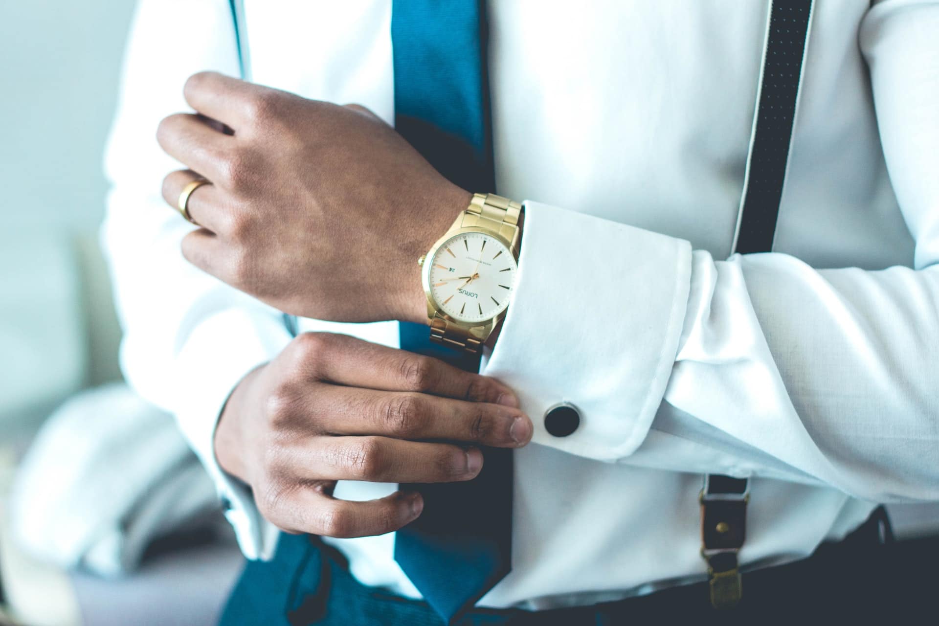 A man with an expensive watch and high end clothes representing a father who's lifestyle is subsidised by a new spouse with means