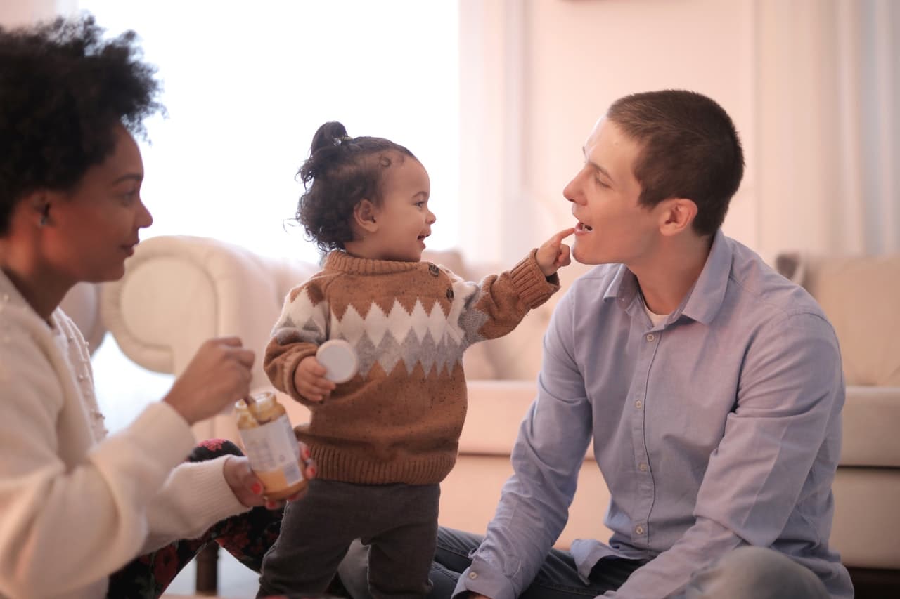 A toddler with her parents representing changes to the adoption process in Alberta under Bill 48