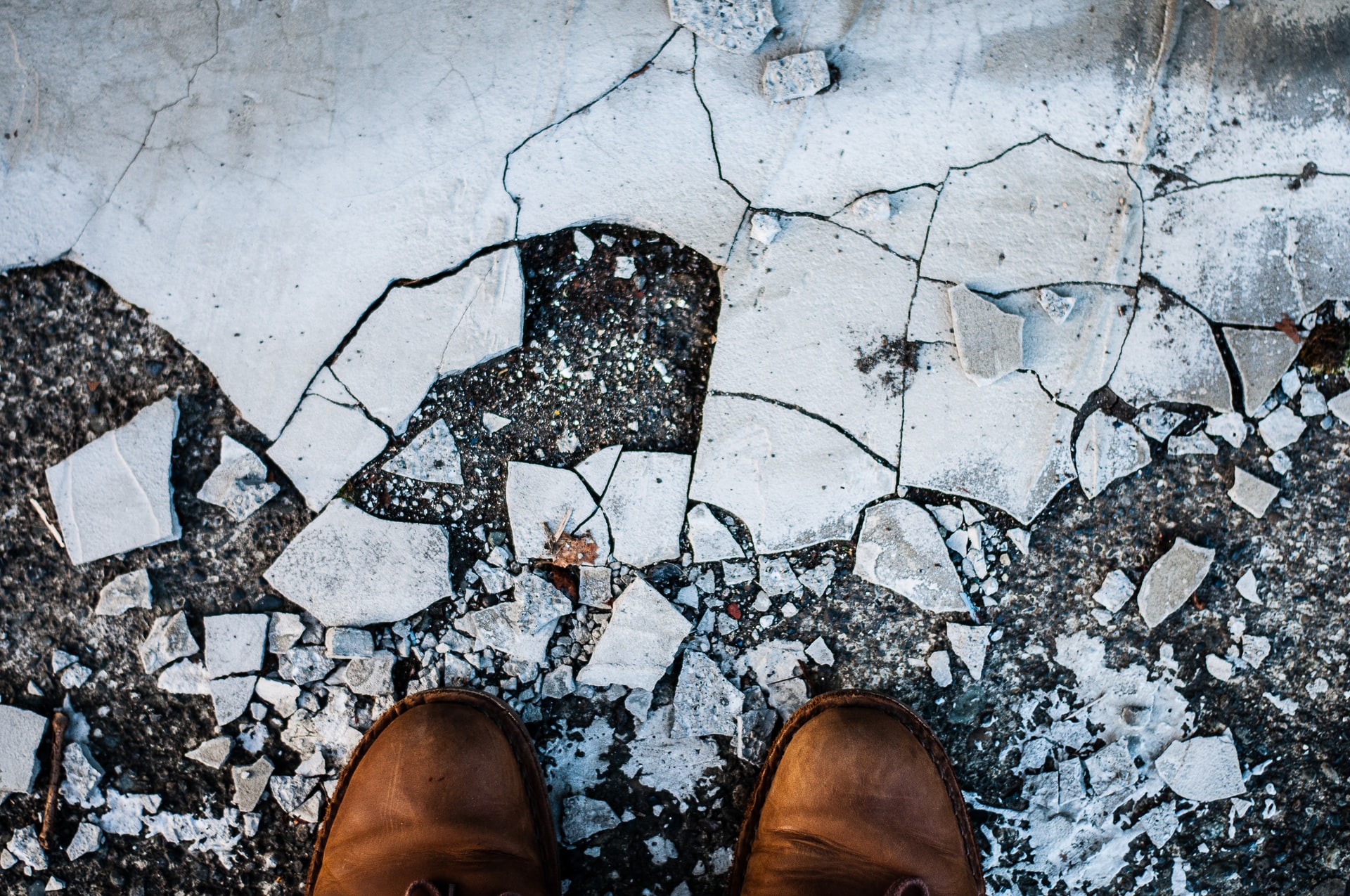 A man standing on broken shards representing a claim for spousal support after partner discovers man led double life