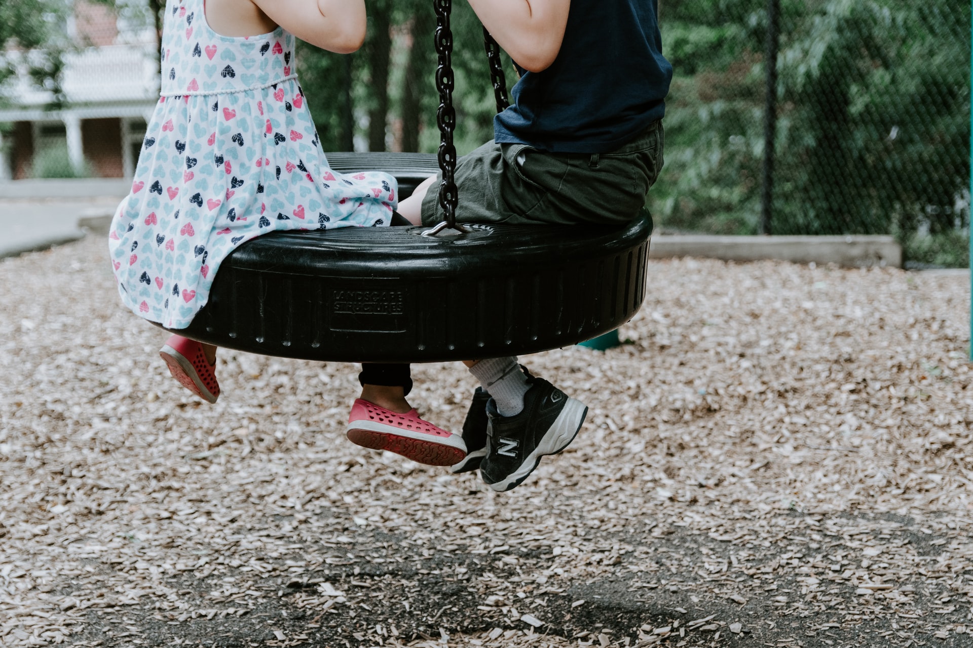 Children playing on tire swing.