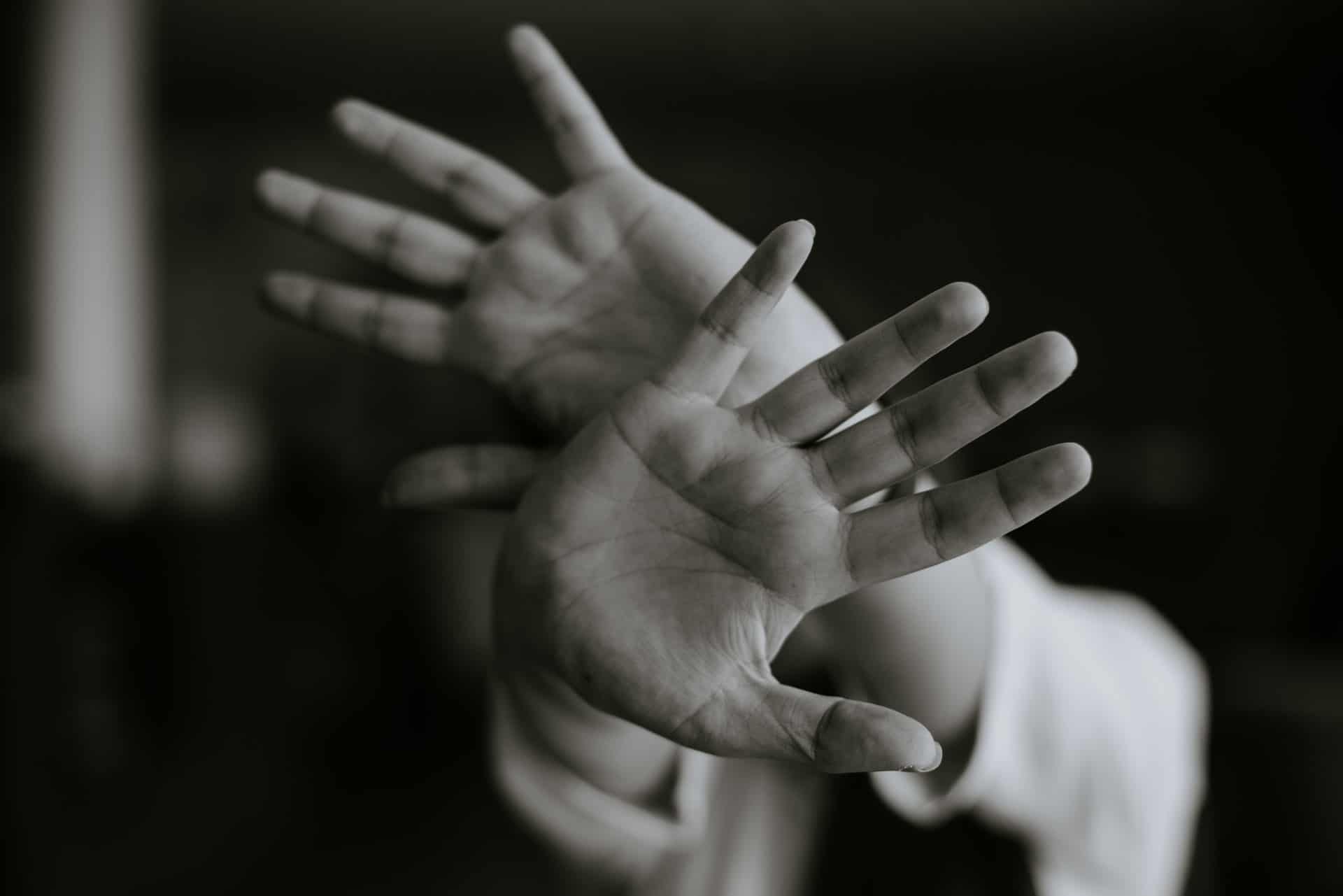 A woman with her arms raised defensively