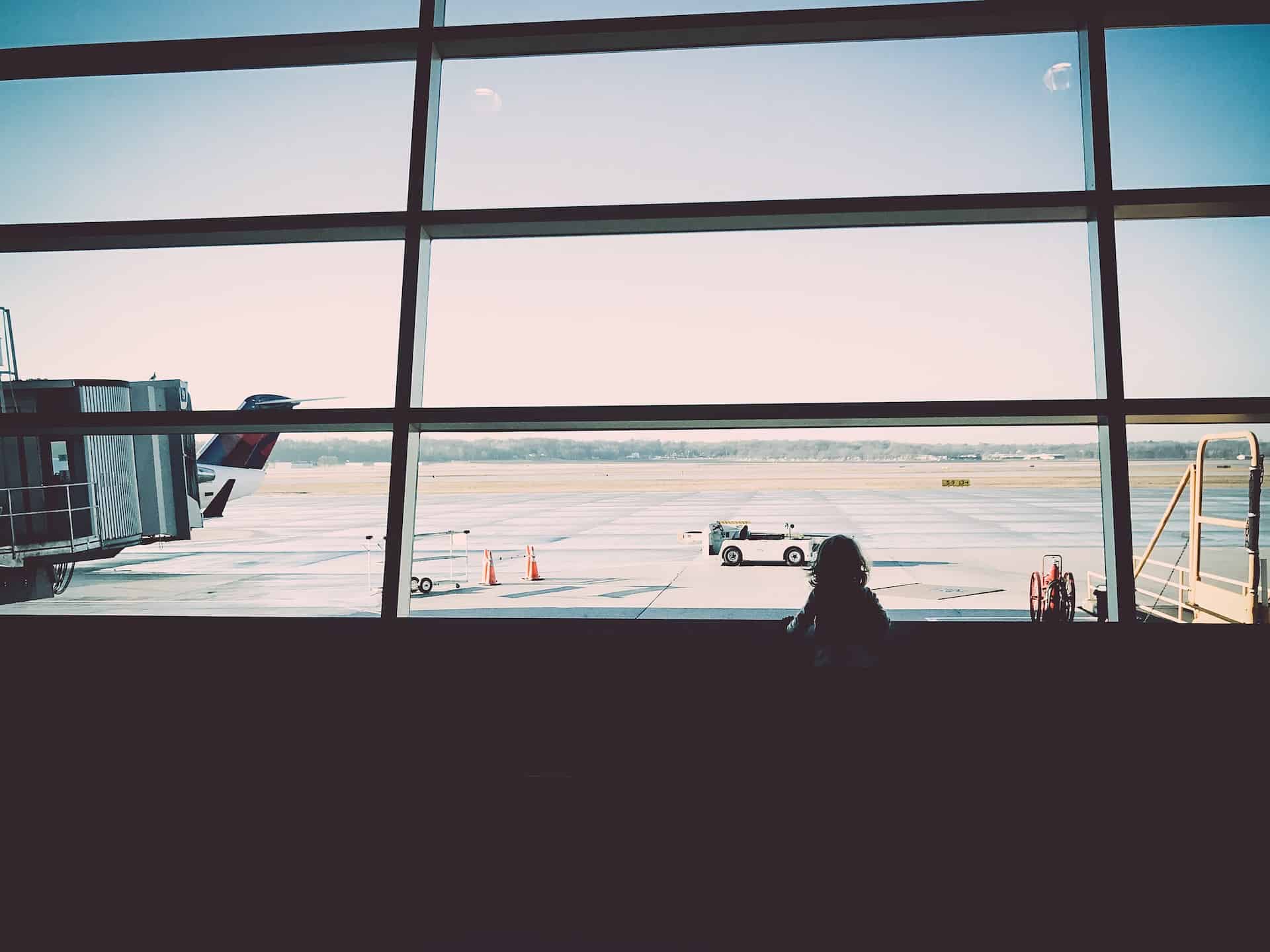 a child looking out the window at an airport