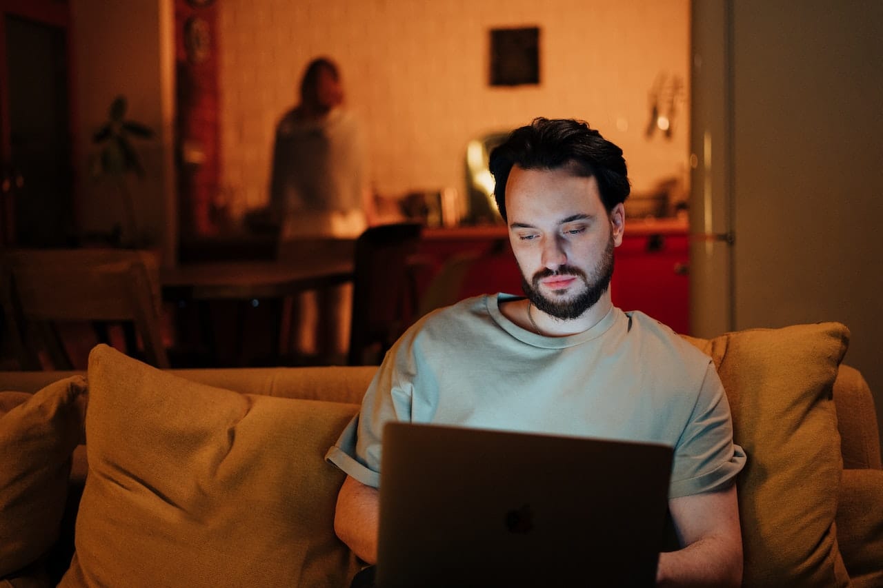 man on laptop while sitting on couch