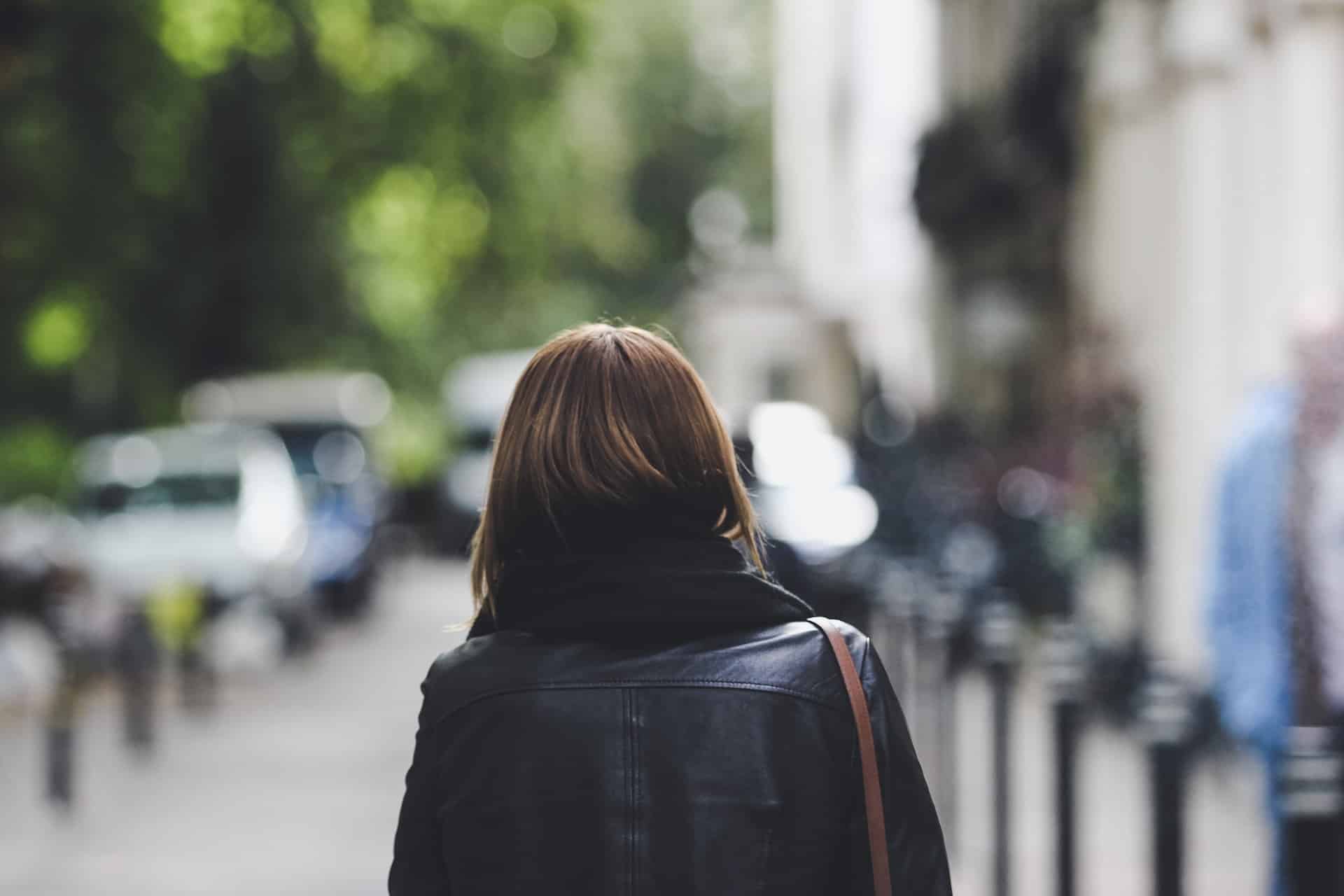 woman wearing black coat walking on street