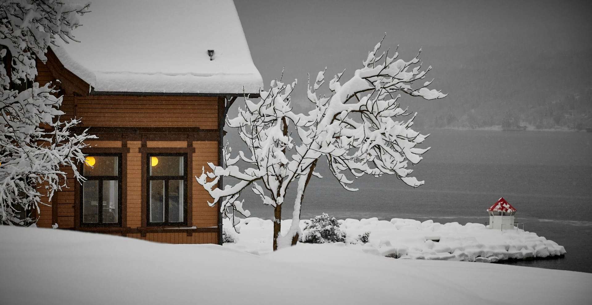 snow covered house on lake