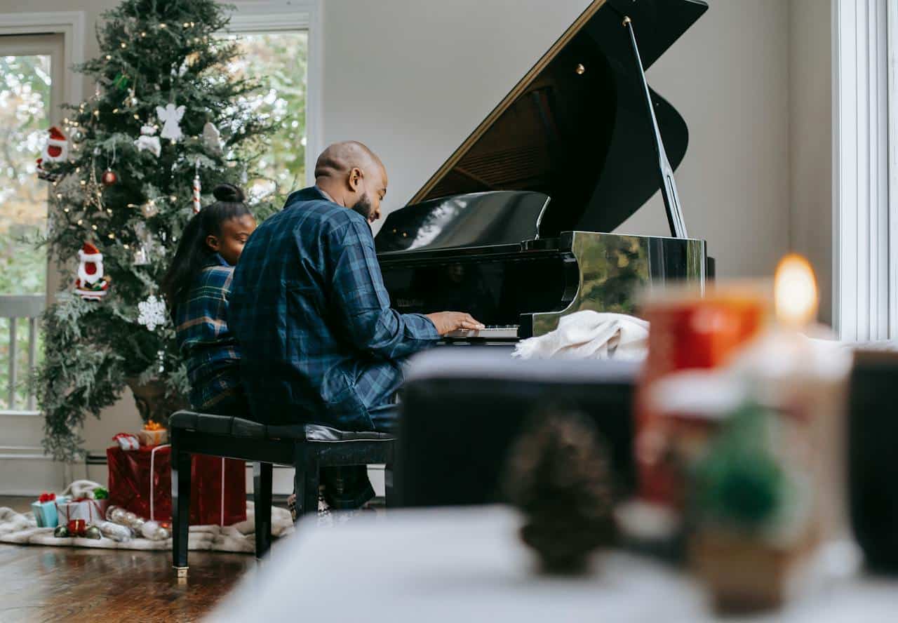 black father playing piano with daughter
