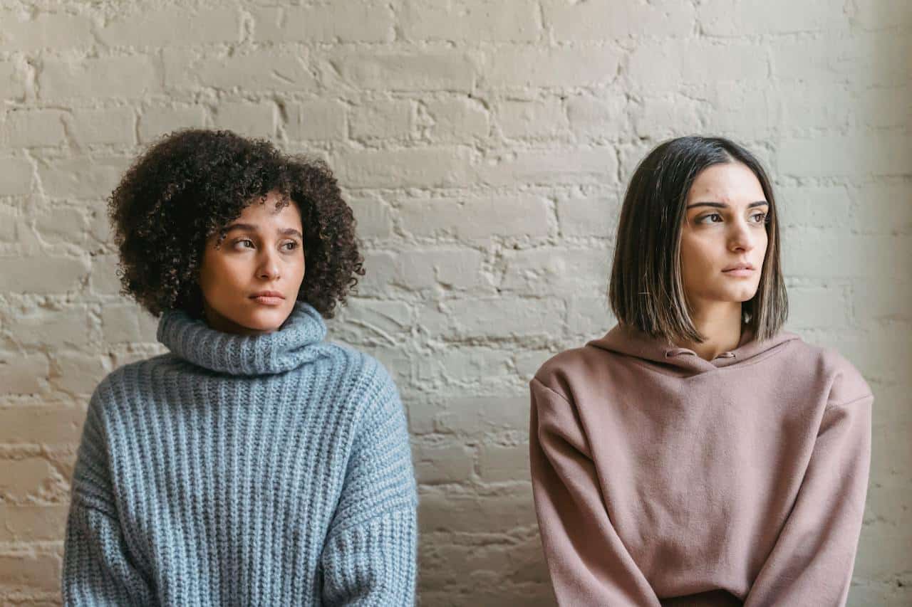 two women standing a part