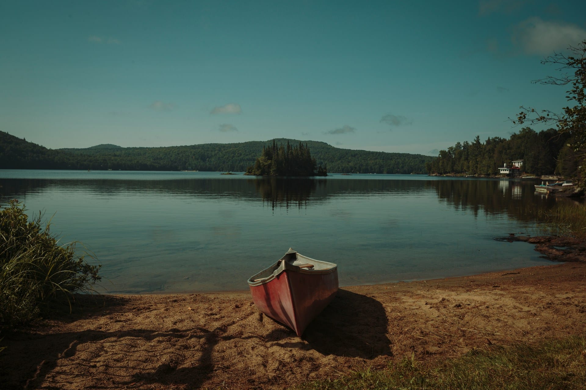 a red canoe pulled up on shore