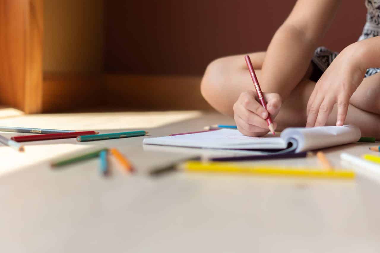 Child colouring representing back to school challenges for divorced parents.