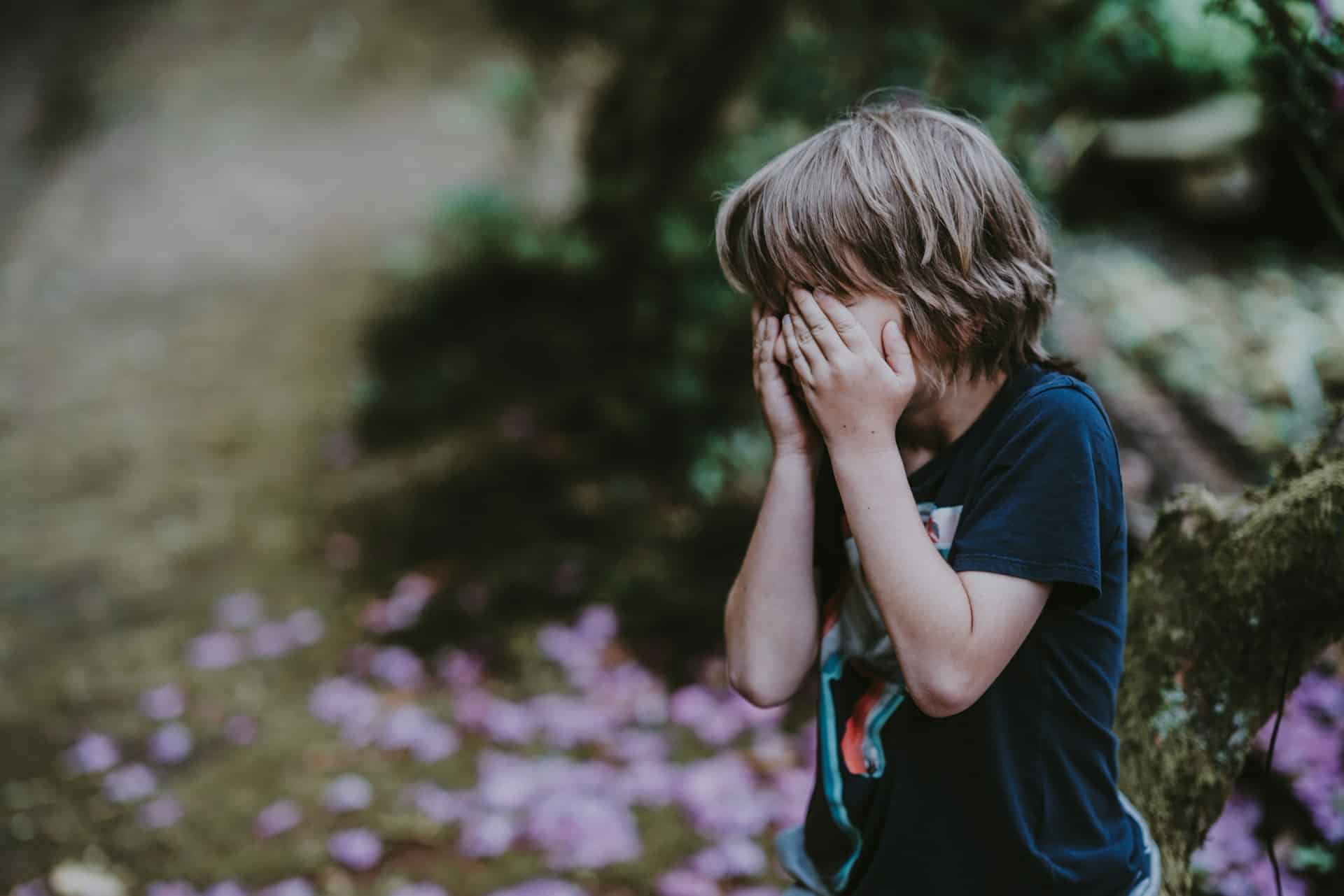 boy covering face with hands