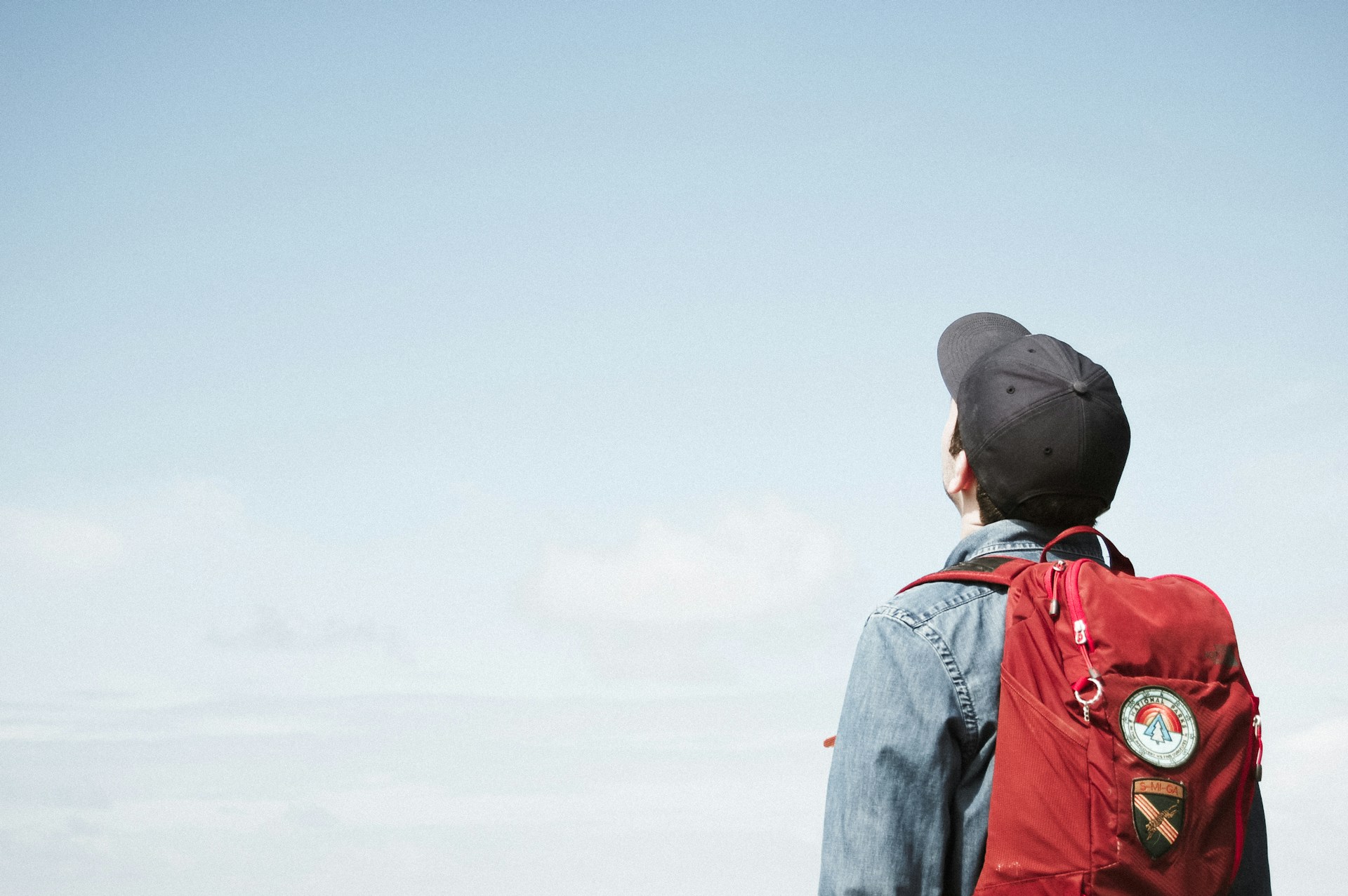 a man looking at sky wearing a backpack