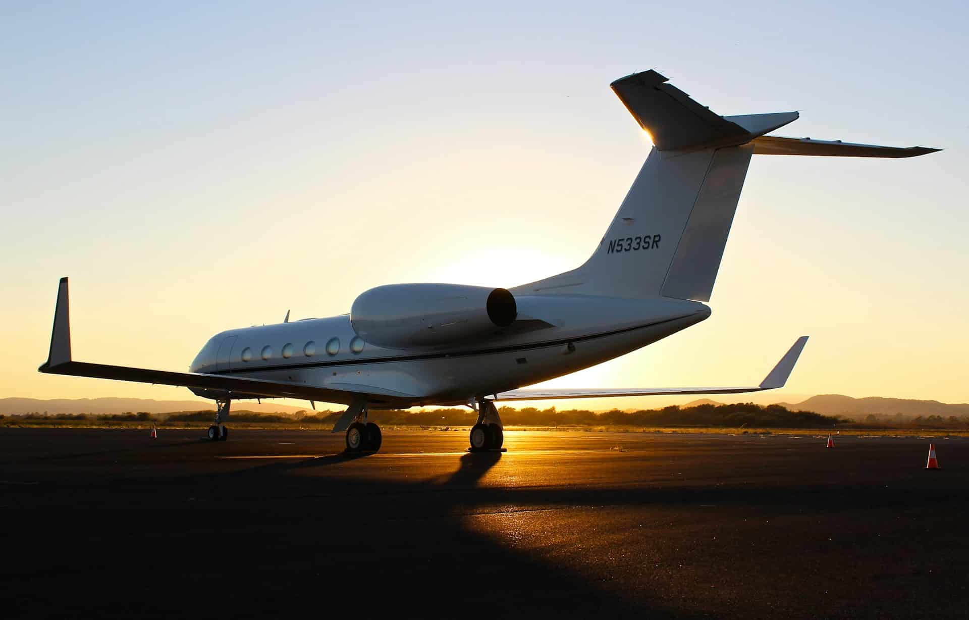 a private jet sitting on a runway at sunset
