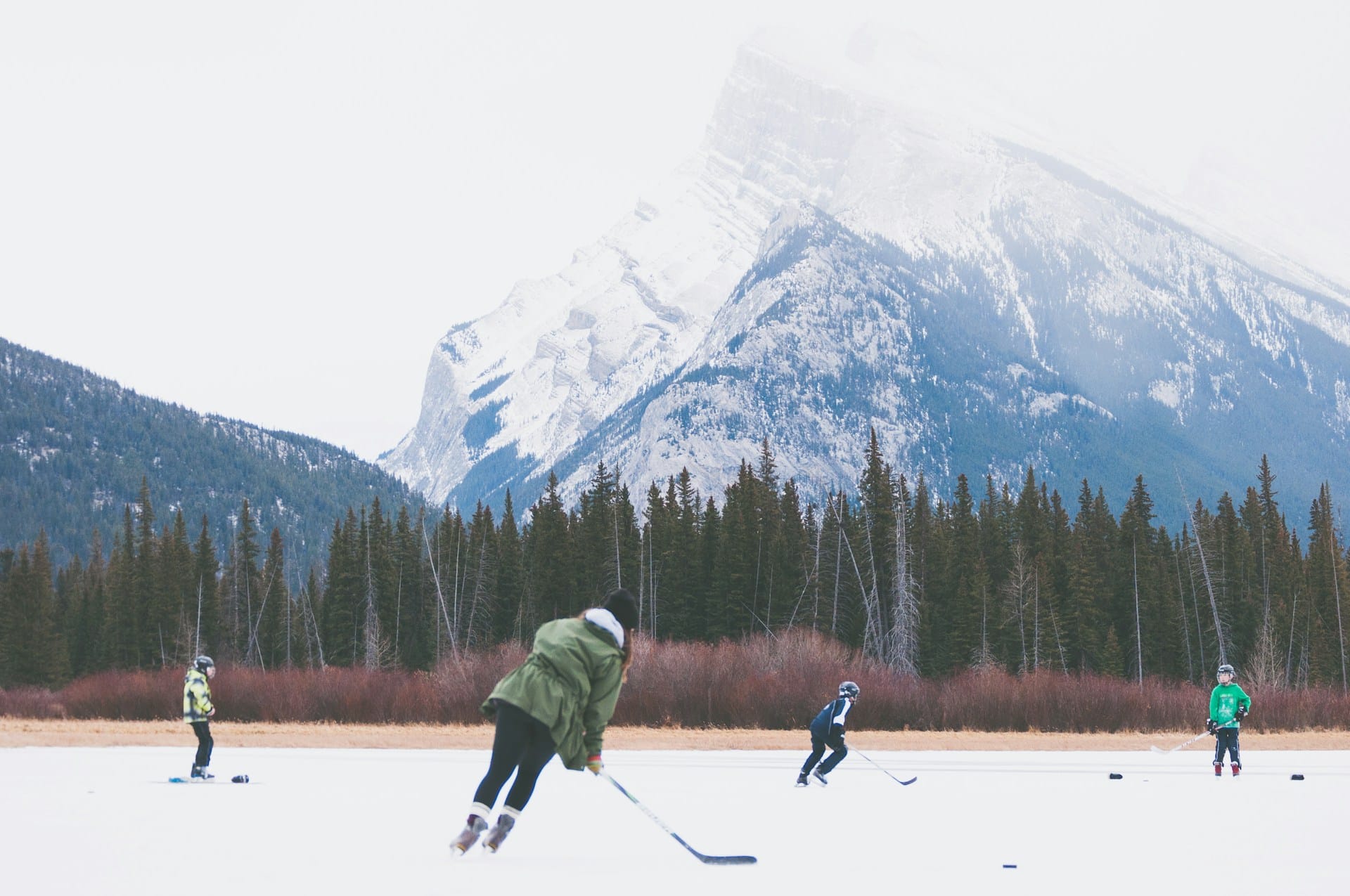 people playing hockey on an outdoor ice rink