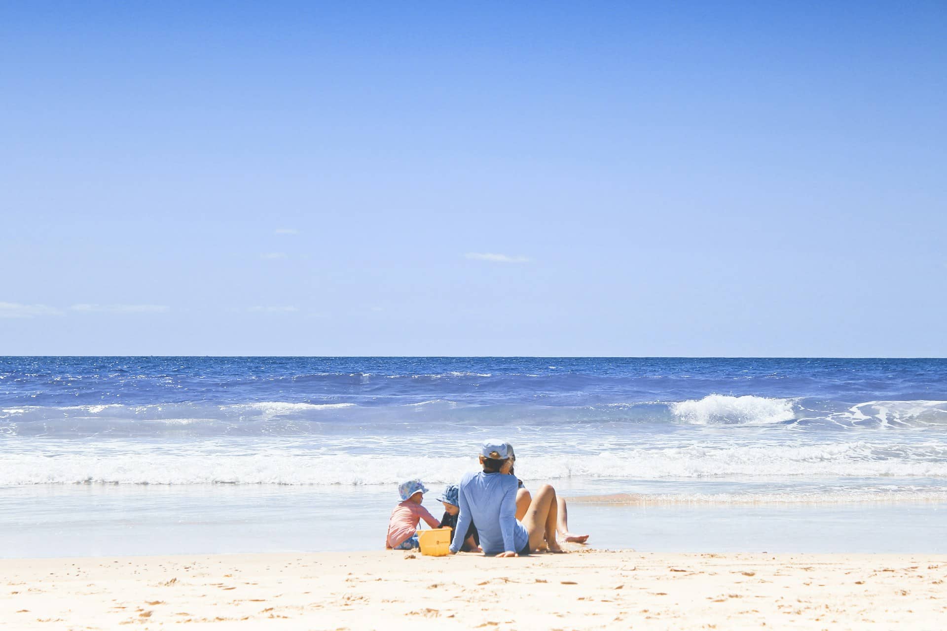 a family on a beach on a sunny day